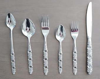 May include: A set of silver flatware with ornate handles. The set includes a knife, fork, and two spoons.