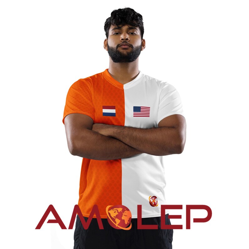 May include: A man wearing a white and orange t-shirt with the Dutch and American flags on the chest. The shirt has a pattern of small orange circles on the orange side. The text "AMOLEP" is printed in red on the bottom of the shirt.