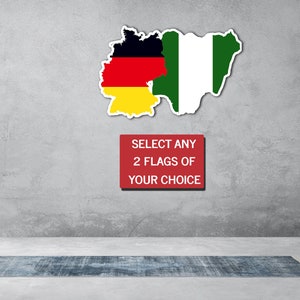 Puede incluir: Una pared con fondo gris, una alfombra, una planta en una maceta dorada y una lámpara de pie. Dos banderas se muestran en la pared, una de Alemania y otra de Nigeria. Un letrero rojo con texto blanco dice "SELECT ANY 2 FLAGS OF YOUR CHOICE".
