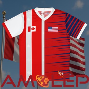 Puede incluir: Una camiseta roja, blanca y azul con cuello en V con las banderas de Canad&aacute; y Estados Unidos. La camiseta tiene mangas blancas y un dise&ntilde;o a rayas rojas y blancas. Las banderas se muestran en la parte delantera de la camiseta.