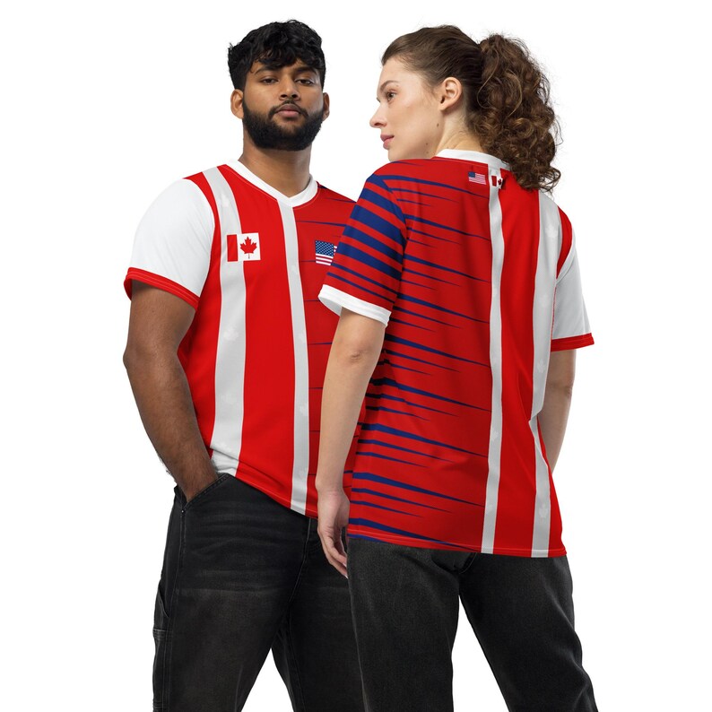Puede incluir: Camisetas a rayas rojas y blancas con cuello en V. Una camiseta presenta la bandera canadiense, la otra la bandera estadounidense. Las camisetas tienen mangas blancas y las llevan dos personas.