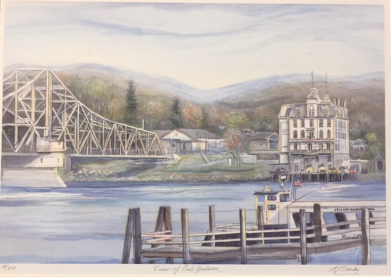 May include: A watercolor painting of a view of East Haddam, Connecticut. The painting features a wooden bridge over a river, a white building with a red roof, and a boat docked at a pier. The painting is signed by the artist, A. Hardy.