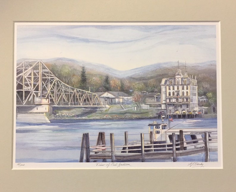 May include: A watercolor painting of a bridge over a river with a white building on the right side of the image. The bridge is made of wood and metal and has a brown and gray color. The building is a large, white structure with a brown roof and many windows. The river is blue and calm. The painting is signed by the artist, "J. Clark", in the lower right corner. The text "View of East Haddam" is written in the lower center of the image.