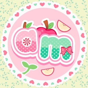 May include: A circular logo with the letters "om" in a playful, cartoon style. The "o" is shaped like a pink apple with a candy center, the "m" is green with a pink bow, and the background is a light green with hearts.
