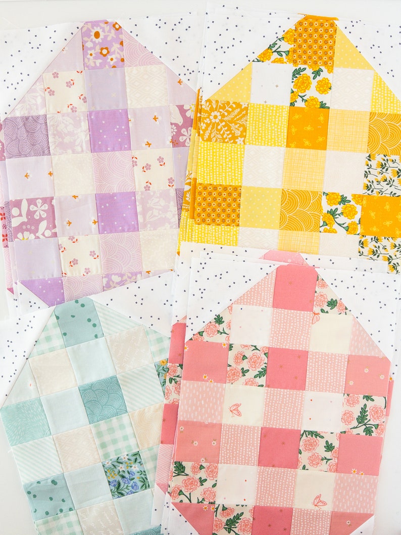 Quilt squares in pink, yellow, purple, and teal patterns are neatly arranged, each featuring floral and checkered designs on a speckled white background.