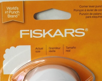 May include: Orange and white corner punch with a scalloped edge design. The packaging includes the text "FISKARS®" and "World's #1 Punch Brand™".