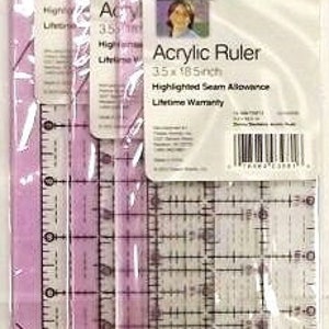 May include: Three clear acrylic rulers with purple edges. The rulers are 3.5 x 18.5 inches and have highlighted seam allowances. The packaging includes the text "Acrylic Ruler" and "Lifetime Warranty".