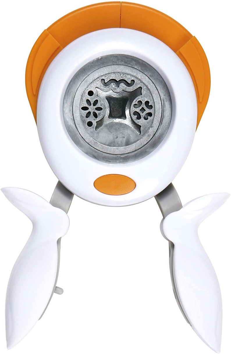 May include: White and orange paper punch with two handles. The punch has a circular cutting area with three different designs: a flower, a wavy line, and a heart.