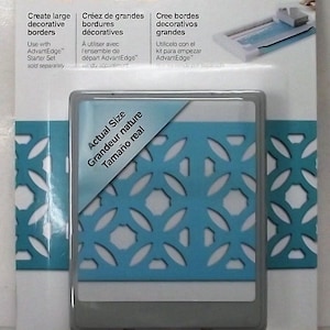 May include: A Fiskars large cartridge for a decorative border punch. The cartridge is shown in a plastic package with a blue and white design. The text on the package reads "Create large decorative borders".