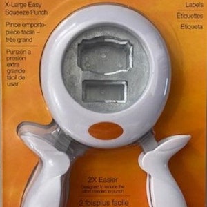 May include: White Fiskars X-Large Easy Squeeze Punch with an orange button. The punch is designed to create labels. The packaging features the text "2X Easier" in English, French, and Spanish.
