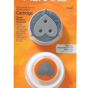 May include: A Fiskars Everywhere Punch™ Window Maker Cartridge for creating heart-shaped designs. The cartridge is orange and white with a gray heart-shaped punch. The packaging is orange and white with the text "World's #1 Punch Brand", "FISKARS®", "Everywhere Punch™ Window Maker Cartridge", "Create Windows Anywhere", "Heart", "Requires Everywhere Punch™ Starter Set sold separately", and "Lifetime Warranty".