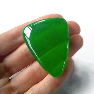 Op de afbeelding: Een groene gitaarplectrum met een gladde, glanzende afwerking.