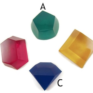 May include: Four colorful, geometric shapes made of plastic. The shapes are labeled A, B, C, and D. Shape A is a green pentagon, shape B is a yellow square, shape C is a blue diamond, and shape D is a red hexagon.