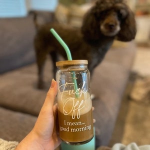Customer photo of customer holding a 20oz cup with white text. Bamboo lid and a teal bent straw are on the cup.