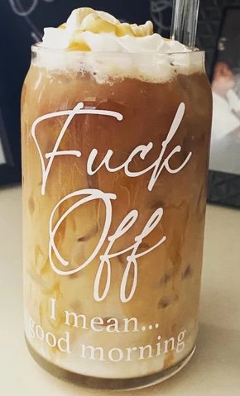 Customer photo showing 16oz glass with white text. Iced coffee is in the cup with a whipped cream topping and a glass straw.