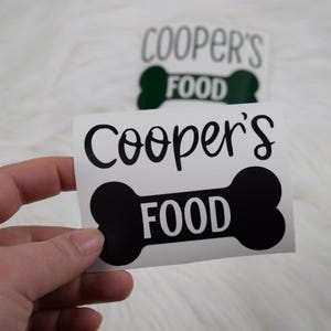 May include: Black and white vinyl sticker with a bone shape and the text "Cooper's Food".