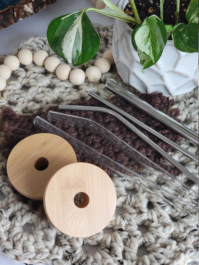 Bamboo lids shown with a slight sheen showing the water resistant finish. Available straws shown are glass straight or bent, stainless steel straight or bent, and stainless steel boba/bubble tea straw.