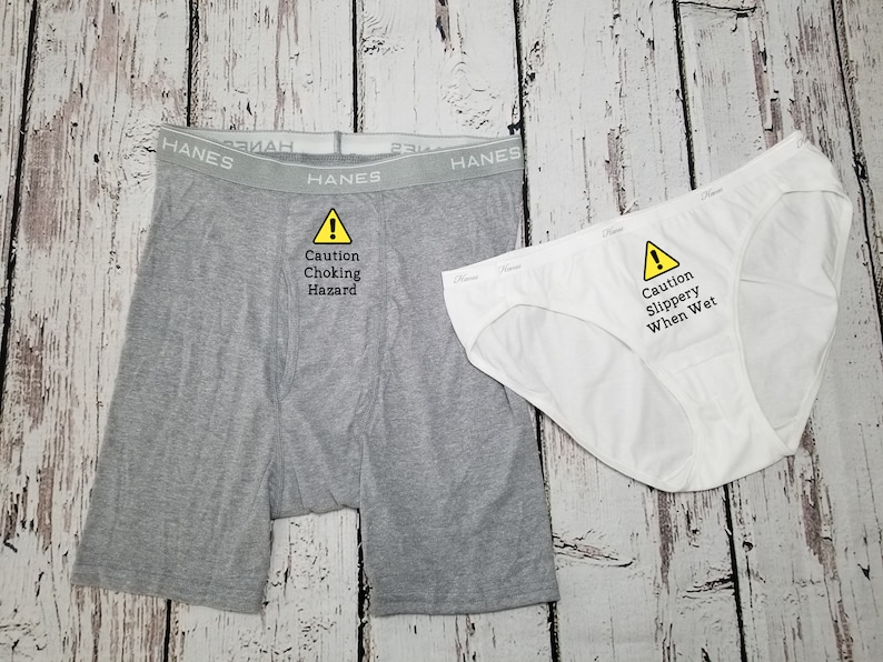 Matching boxer briefs and bikini underwear with saying on front. Men's says caution choking hazard, women's says caution slippery when wet. Women's comes in black or white thong or bikini, men's comes in black or grey boxer briefs.