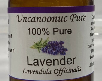 Op de afbeelding: Een bruine glazen fles lavendel etherische olie met een zwarte dop. Het etiket luidt "Uncanoonuc Pure 100% Pure Lavender Lavendula Officinalis". De fles bevat 30 ml olie.