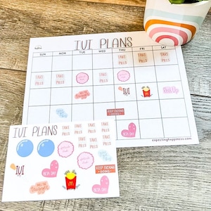 May include: A printable calendar with the words "IVI Plans" at the top. The calendar is divided into seven days of the week, with each day having a space for a sticker. There are several stickers with different designs, including hearts, pills, and a McDonald's logo. The stickers are pink, blue, and red.