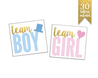 Könnte beinhalten: Zwei temporäre Tattoos für eine Geschlechter-Enthüllungsfeier. Ein Tattoo sagt "team boy" in goldenen Buchstaben mit einem blauen Zylinder. Das andere Tattoo sagt "team girl" in goldenen Buchstaben mit einem rosa Herzen.
