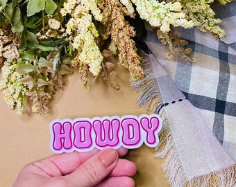 May include: Pink "HOWDY" sticker with a white outline. The sticker has a retro, bubbly font.