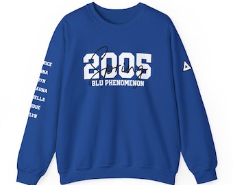 Puede incluir: Una sudadera de cuello redondo azul real con el texto blanco 2005 y BLU PHENOMENON, junto a la palabra Spring en letra cursiva negra. La manga izquierda muestra una lista de nombres en blanco y un pequeño logo triangular blanco.