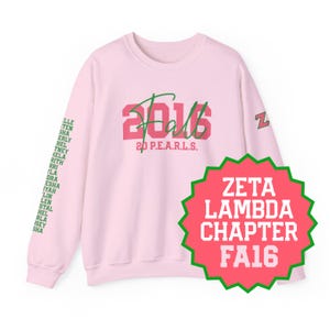 May include: A light pink long-sleeve sweatshirt featuring the text 2016 Fall 20 P.E.A.R.L.S. in pink and green on the chest. The left sleeve displays a list of names in green, while the right sleeve features a green and pink Z logo.