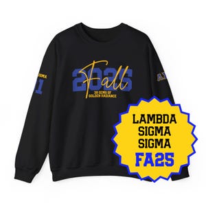 May include: Black sweatshirt with the word "Fall" in blue and gold script, with the year "2025" in blue. The sleeve has the word "ISMA" and the number "1". A yellow and blue starburst graphic reads "LAMBDA SIGMA SIGMA FA25".
