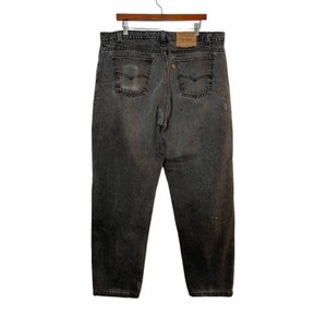 May include: A pair of dark gray denim jeans with a faded look and a small orange Levi's label on the back pocket.