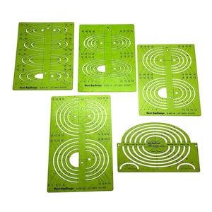 May include: A collection of five green plastic ellipse templates. Each template features various ellipse sizes and angles, with markings for precise drawing. The templates are labeled with the "Berol RapiDesign" brand and model numbers.