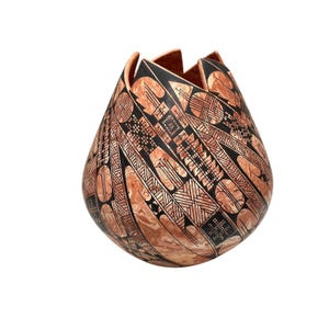 May include: A handcrafted, decorative vase with a unique, organic shape. The vase features a warm, reddish-brown base color with intricate black geometric patterns. The top edge has a scalloped design.