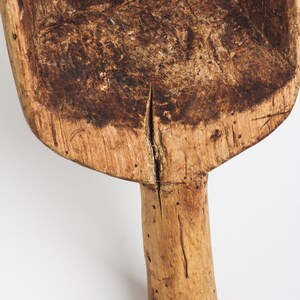 Puede incluir: Una pala de madera con un mango largo. La pala est&aacute; hecha de madera marr&oacute;n claro y tiene una p&aacute;tina marr&oacute;n oscuro. El mango est&aacute; ligeramente curvado y tiene algunos nudos.