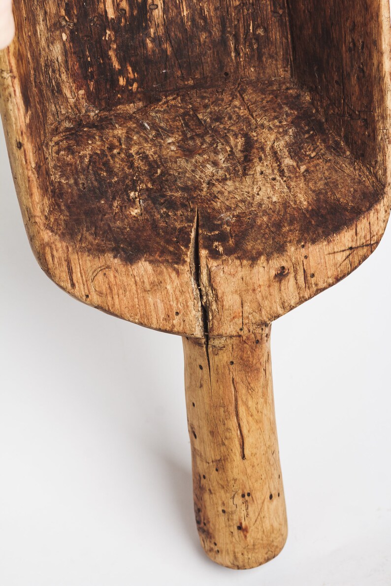 Puede incluir: Una pala de madera con un mango largo. La pala est&aacute; hecha de madera marr&oacute;n claro y tiene una p&aacute;tina marr&oacute;n oscuro. El mango est&aacute; ligeramente curvado y tiene algunos nudos.