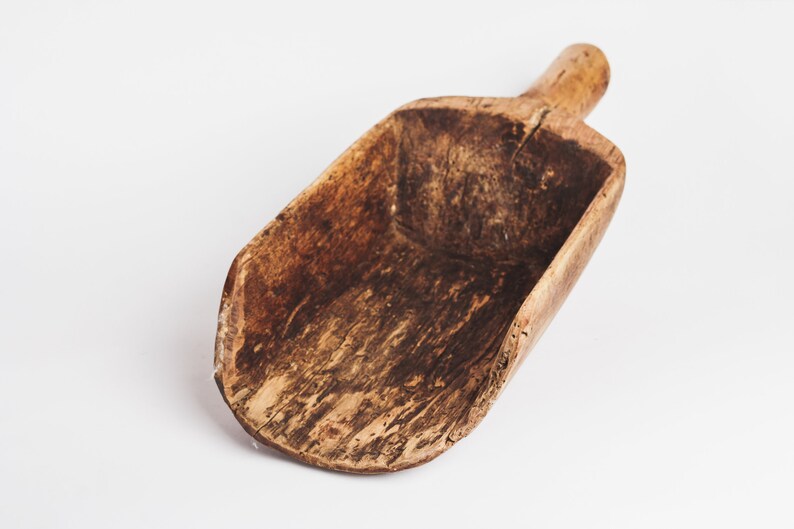 Puede incluir: Una pala de madera con un acabado marr&oacute;n desgastado. La pala est&aacute; hecha de una sola pieza de madera y tiene un mango en un extremo.