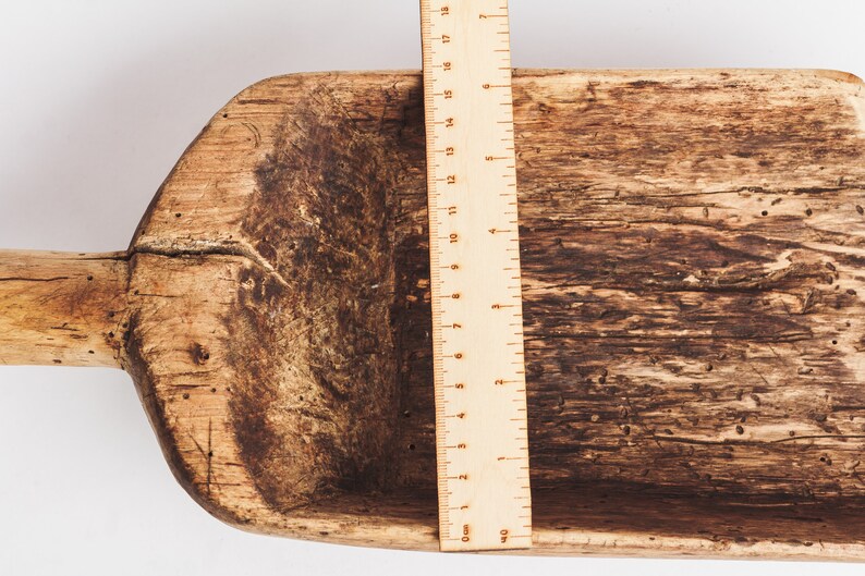 Puede incluir: Una pala de madera con un mango largo, que mide 45,7 cm de longitud. La pala est&aacute; hecha de madera marr&oacute;n oscura con un aspecto desgastado y r&uacute;stico.