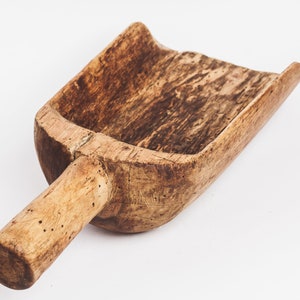 Puede incluir: Una pala de madera con un mango largo. La pala est&aacute; hecha de madera marr&oacute;n claro y tiene un aspecto desgastado y r&uacute;stico.