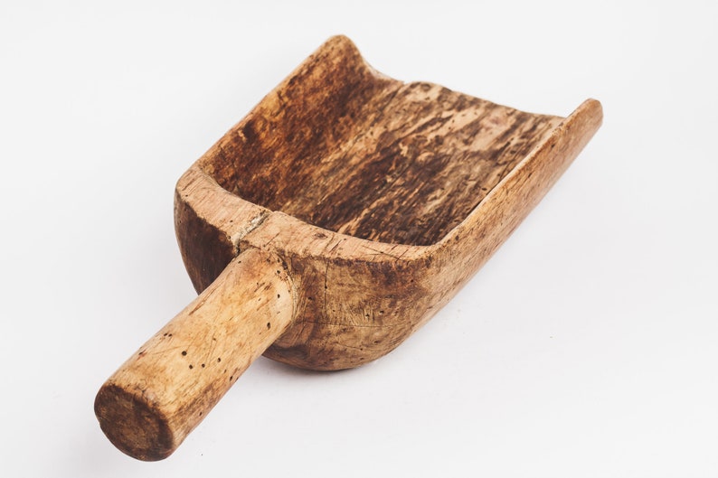 Puede incluir: Una pala de madera con un mango largo. La pala est&aacute; hecha de madera marr&oacute;n claro y tiene un aspecto desgastado y r&uacute;stico.