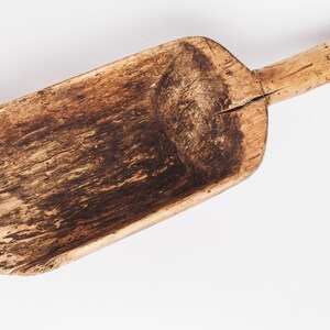 Puede incluir: Una pala de madera vintage con un mango largo. La pala est&aacute; hecha de madera marr&oacute;n oscura y tiene un aspecto desgastado y r&uacute;stico.