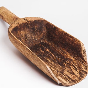 Puede incluir: Una pala de madera vintage con un mango largo. La pala est&aacute; hecha de madera marr&oacute;n oscura con un patr&oacute;n de veta natural. Tiene un aspecto desgastado y envejecido, lo que sugiere que se ha utilizado durante muchos a&ntilde;os.