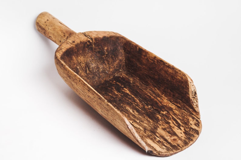Puede incluir: Una pala de madera vintage con un mango largo. La pala est&aacute; hecha de madera marr&oacute;n oscura con un patr&oacute;n de veta natural. Tiene un aspecto desgastado y envejecido, lo que sugiere que se ha utilizado durante muchos a&ntilde;os.