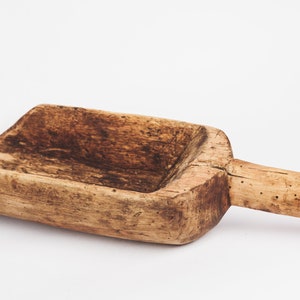 Puede incluir: Una pala de madera r&uacute;stica con un acabado marr&oacute;n desgastado y un mango. La pala est&aacute; hecha de madera natural y tiene un dise&ntilde;o simple y funcional.