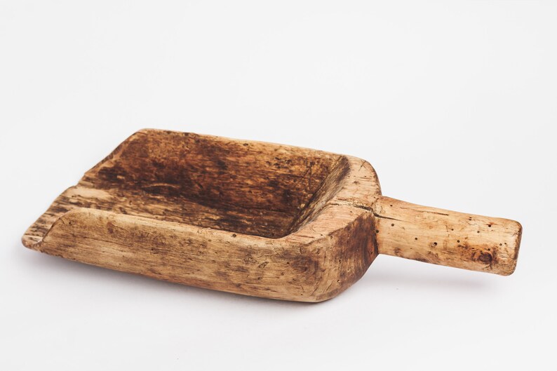 Puede incluir: Una pala de madera r&uacute;stica con un acabado marr&oacute;n desgastado y un mango. La pala est&aacute; hecha de madera natural y tiene un dise&ntilde;o simple y funcional.