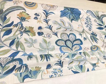 May include: A white fabric with a blue and green floral pattern. The fabric has a subtle texture and a slightly distressed look. The floral pattern is intricate and features a variety of leaves, flowers, and swirls.
