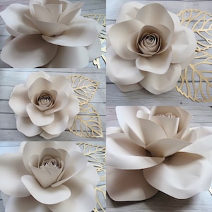 May include: Four large, cream-colored paper roses with a layered, ruffled design. The roses are arranged in a collage with gold leaf accents.