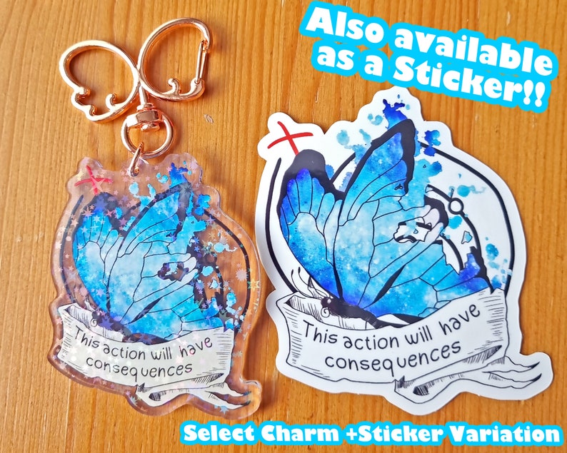 May include: A blue butterfly charm with glitter and the text "This action will have consequences" on a white background. The charm is attached to a gold key chain. The image also shows a sticker with the same design and text.