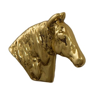 May include: A gold-colored horse head sculpture. The sculpture is detailed with textured fur and a realistic expression.