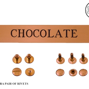 May include: A copper-coloured metal sign with rounded edges and two holes. The sign reads "CHOCOLATE" in black lettering. The sign comes with an extra pair of rivets and a set of screws and rivets.
