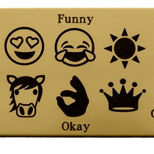 May include: A gold-coloured metal plaque with black engraved text and icons. The text reads "Love", "Horse", "Funny", "Okay", "Sun", and "Queen". The icons are a heart-eyed smiley face, a laughing smiley face, a sun, a horse, an okay hand gesture, and a crown.
