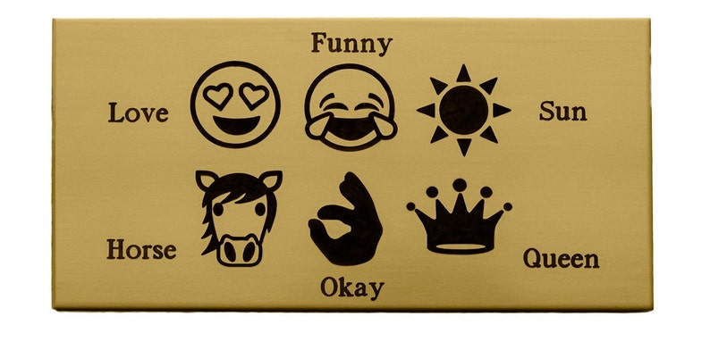 May include: A gold-coloured metal plaque with black engraved text and icons. The text reads "Love", "Horse", "Funny", "Okay", "Sun", and "Queen". The icons are a heart-eyed smiley face, a laughing smiley face, a sun, a horse, an okay hand gesture, and a crown.